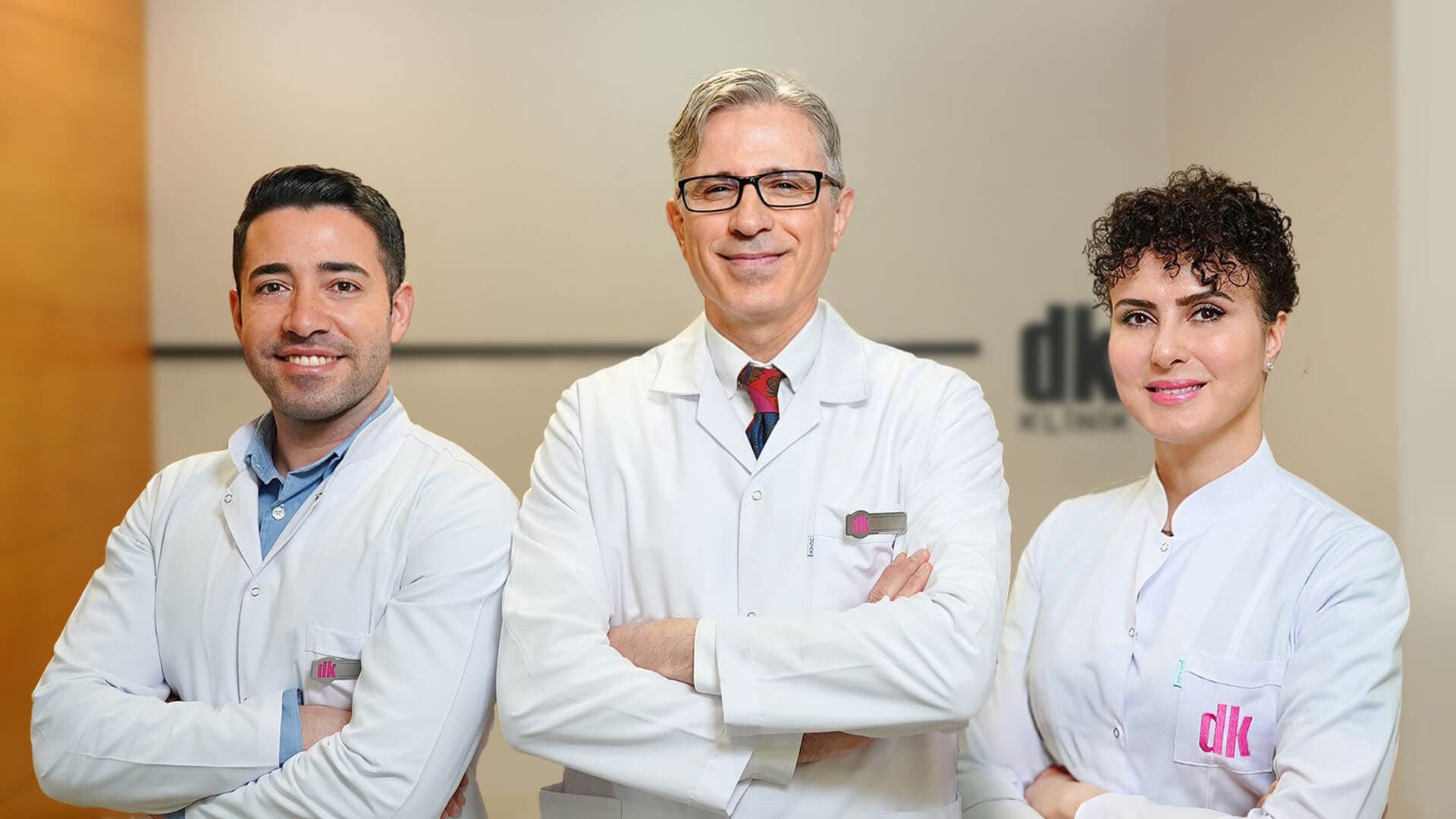 Three DK Hair Klinik doctors in white coats standing in the clinic