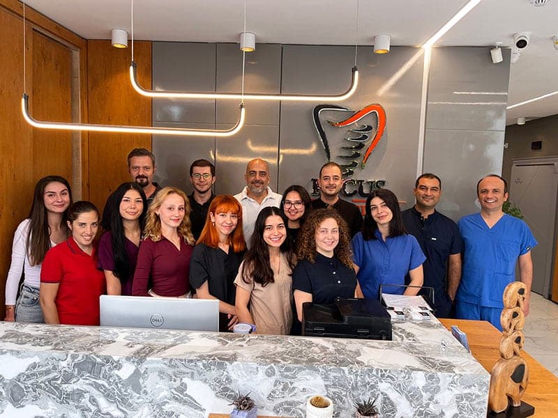 The Focus Dental Clinic team standing together behind the reception desk